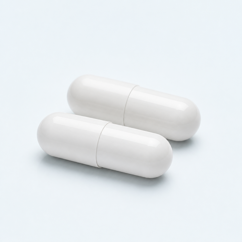 Two plain white capsules on a clean studio background